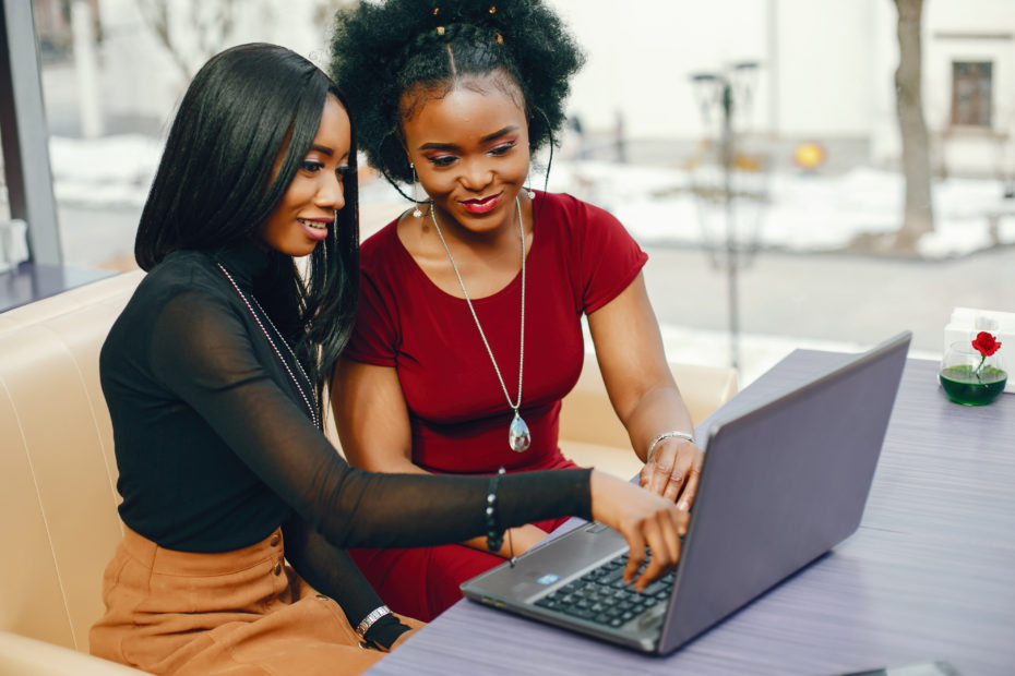 Two attractive women working with a computer